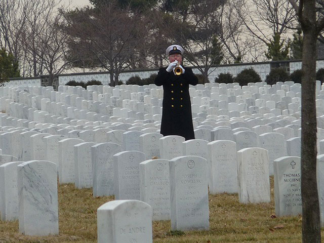 Man playing a trumpet in a cemetery